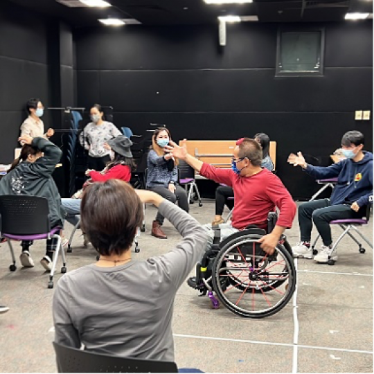 Philip (man in red) leads the participants to perform samba dance on rolling chairs.