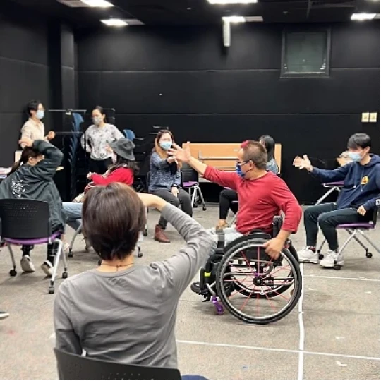 有肢體障礙的輪椅舞者黃和洲（紅衣）帶領參加者在滾椅上表演森巴舞。