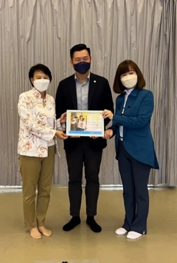 Members of Hong Kong Committee for UNICEF Mrs Cherry Tse (left) and Dr Barbara Lam (right) present a souvenir to Mr Christopher Ng, Assistant Director (External Affairs) of HKAPA